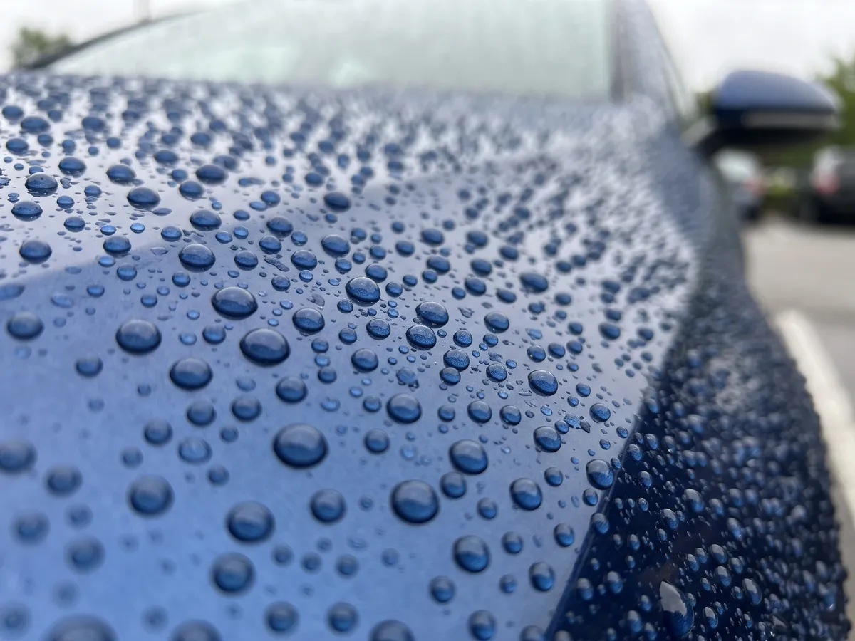 Unser Angebot - Glanznormal Fahrzeugaufbereitung Wasser perlt in runden Tropfen auf frisch versiegeltem Lack ab